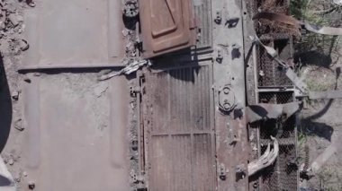 This stock vertical video shows an aerial view of destroyed military equipment in Ukraine, flat, grey video