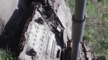 This stock vertical video shows an aerial view of destroyed military equipment in Ukraine, flat, grey video