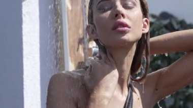 This stock slow motion video shows a sexy woman taking a shower