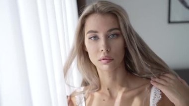 This stock video shows a beautiful woman in sexy lingerie, slow motion