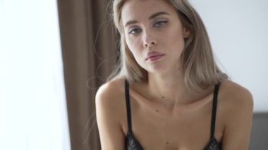 This stock video shows a beautiful woman in sexy lingerie, slow motion
