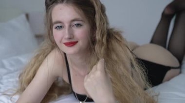 This stock video shows a beautiful girl in sexy lingerie, slow motion