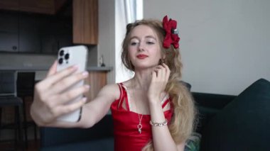 This stock video shows a young girl taking a selfie on her phone, slow motion