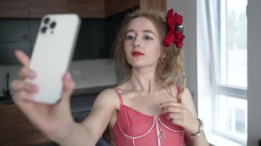 This stock video shows a young girl taking a selfie on her phone, slow motion