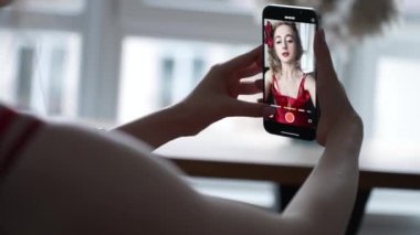 This stock video shows a young girl taking a selfie on her phone, slow motion