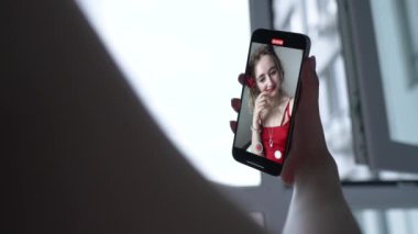 This stock video shows a young girl taking a selfie on her phone, slow motion