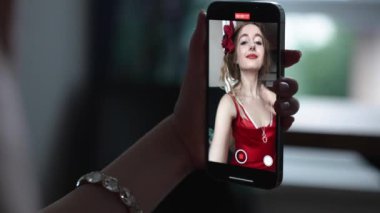This stock video shows a young girl taking a selfie on her phone, slow motion