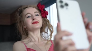 This stock video shows a young girl taking a selfie on her phone, slow motion