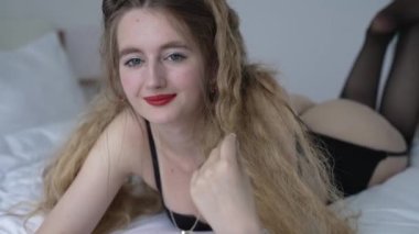 This stock video shows a beautiful woman in sexy lingerie, slow motion