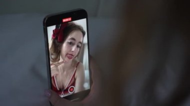 This stock video shows a young girl taking a selfie on her phone, slow motion