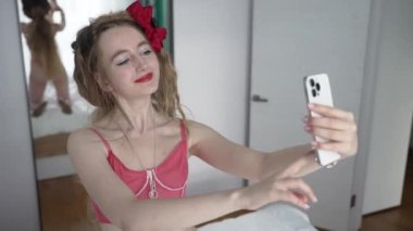 This stock video shows a young girl taking a selfie on her phone, slow motion