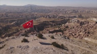Bu stok görüntüler, Kapadokya 'daki bir dağın tepesindeki Türkiye bayrağının 8K çözünürlükteki hava görüntüsünü gösteriyor.