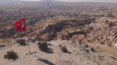 Bu stok görüntüler, Kapadokya 'daki bir dağın tepesindeki Türkiye bayrağının 8K çözünürlükteki hava görüntüsünü gösteriyor.