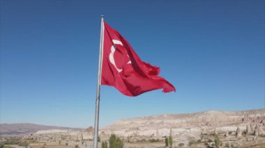 Bu stok görüntüler, Kapadokya 'daki bir dağın tepesindeki Türkiye bayrağının 8K çözünürlükteki hava görüntüsünü gösteriyor.