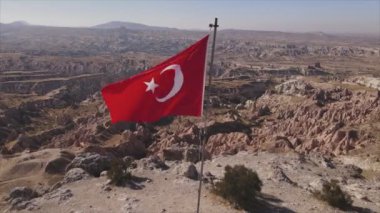 Bu stok görüntüler, Kapadokya 'daki bir dağın tepesindeki Türkiye bayrağının 8K çözünürlükteki hava görüntüsünü gösteriyor.