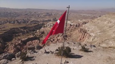 Bu stok görüntüler, Kapadokya 'daki bir dağın tepesindeki Türkiye bayrağının 8K çözünürlükteki hava görüntüsünü gösteriyor.