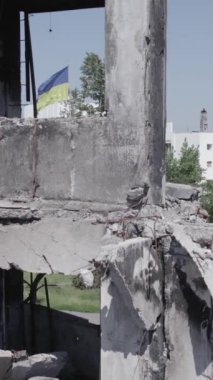 Bu stok dikey video, Borodyanka, Bucha bölgesinde gri, renksiz, düz bir bina gösteriyor.