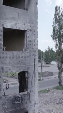 Bu stok dikey video, Borodyanka, Bucha bölgesinde gri, renksiz, düz bir bina gösteriyor.