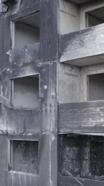 Bu stok dikey video, Borodyanka, Bucha bölgesinde gri, renksiz, düz bir bina gösteriyor.