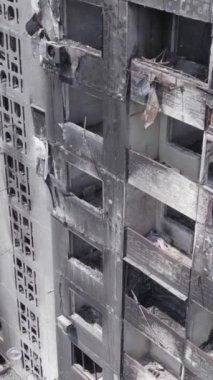 Bu stok dikey video, Borodyanka, Bucha bölgesinde gri, renksiz, düz bir bina gösteriyor.