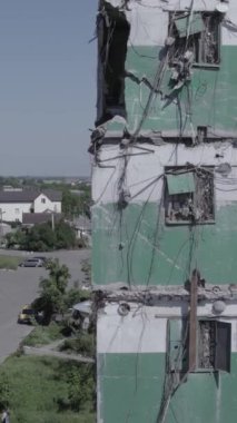 Bu stok dikey video, Borodyanka, Bucha bölgesinde gri, renksiz, düz bir bina gösteriyor.