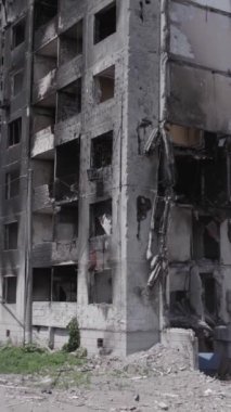 Bu stok dikey video, Borodyanka, Bucha bölgesinde gri, renksiz, düz bir bina gösteriyor.