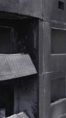 Bu stok dikey video, Borodyanka, Bucha bölgesinde gri, renksiz, düz bir bina gösteriyor.
