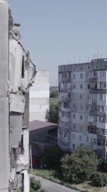 Bu stok dikey video, Borodyanka, Bucha bölgesinde gri, renksiz, düz bir bina gösteriyor.