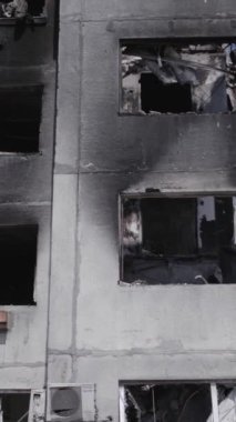 Bu stok dikey video, Borodyanka, Bucha bölgesinde gri, renksiz, düz bir bina gösteriyor.