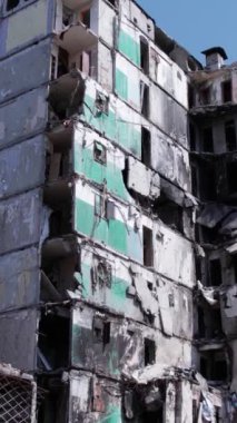 Bu stok dikey video, Borodyanka, Bucha bölgesinde gri, renksiz, düz bir bina gösteriyor.