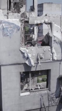 Bu stok dikey video, Borodyanka, Bucha bölgesinde gri, renksiz, düz bir bina gösteriyor.