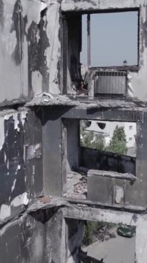 Bu stok dikey video, Borodyanka, Bucha bölgesinde gri, renksiz, düz bir bina gösteriyor.