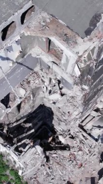 Bu stok dikey video, Borodyanka, Bucha bölgesinde gri, renksiz, düz bir bina gösteriyor.