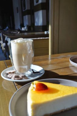 Cheesecake ve Viyana kahvesi bir kafede masanın üstünde. 