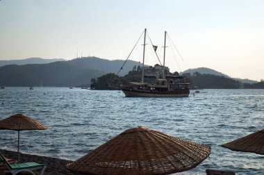  Fethiye 'nin kumsalı yakınındaki körfezde gemi kalkıyor..