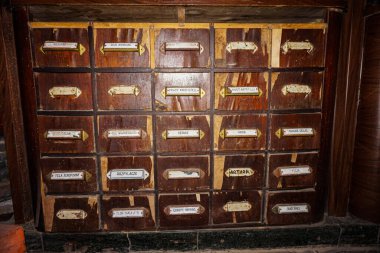 Lviv 'deki eczane müzesinde tarihi geçmiş uyuşturucu isimleri olan antika raflar.          