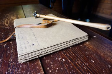 Masanın üzerinde açık eski bir kitap yatıyor..        