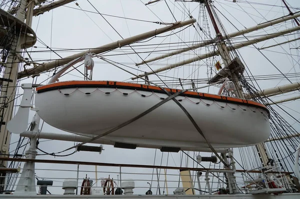 The lifeboat is attached to the side of the ship.