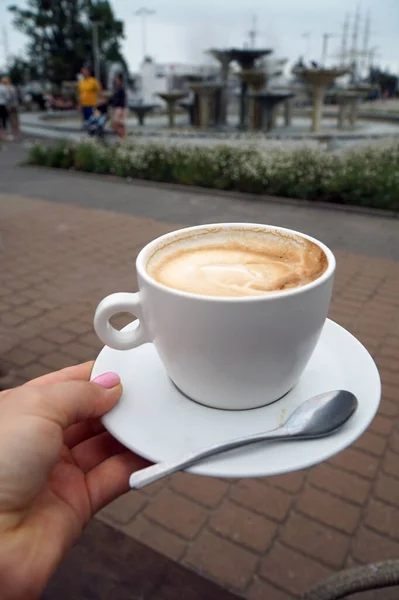 A cup of coffee on the background of the Baltic sea embankment.