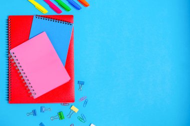 Mavi arka planda işaretleri olan notlar için farklı boyutlarda defterler. Okul hazırlığı kavramı, kırtasiye. Düz yatış, üst görünüm.