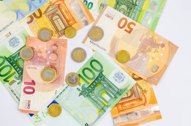 Background from various paper banknotes and euro coins on a white background. The concept of money, economy, finance, savings. Close-up