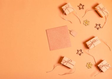 Boş kart, hediye kutuları ve sıfır atık malzemeden alınmış yeni yıl oyuncakları bej bir arka planda mesaj için yer var. Yeni yıl ve Noel tatili kavramı, tebrikler. Yukarıdan görüntüle