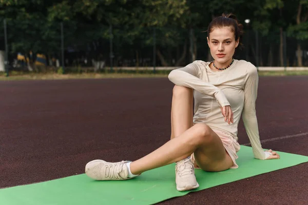 Sportig kvinnlig vacker modell går in för sport utomhus och tittar på kameran — Stockfoto