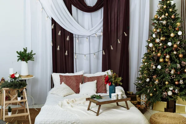 현대적 인 침실의 내부는 크리스마스를 위해 장식되어 있다. 아파트에 있는 크리스마스 트리. — 스톡 사진