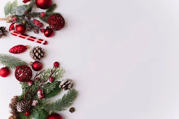 Composizione natalizia con rami di abete, decorazioni rosse su sfondo bianco con spazio per copiare il testo. Natale, inverno, capodanno. Layout piatto, vista dall'alto, spazio di copia — Foto Stock