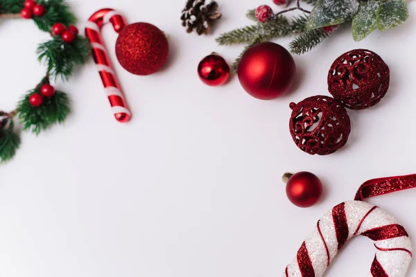 Beyaz arka planda kırmızı oyuncakları ve topları olan bir ağacın dallarının Noel fotoğrafı.