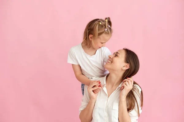 Lovely beautiful young mother and little daughter hug and look at each other. Photo in the studio. Copy space. — ストック写真