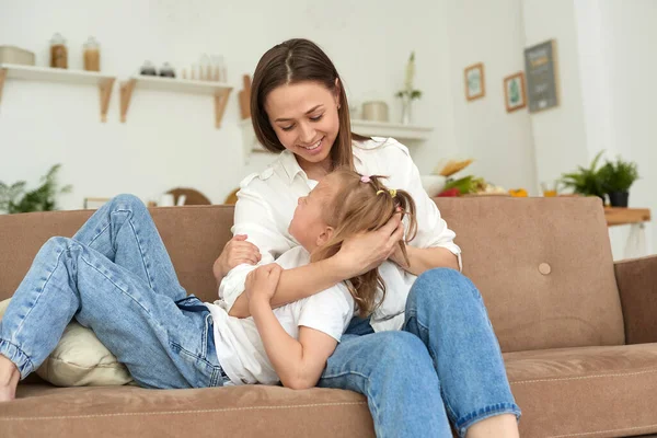 Mom listens to her little daughters problems, hugs and comforts her. Caring mother supporting upset daughter, talking, discussing problems, trusted family relationship concept, loving mum comforting — Stock Photo, Image