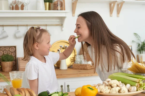 Anne ve kızı mutfakta bir salata hazırlayın. Mutlu sevgi dolu aile birlikte hazırlanıyor. Sağlıklı beslenme ve yaşam tarzı kavramı. Aile değeri