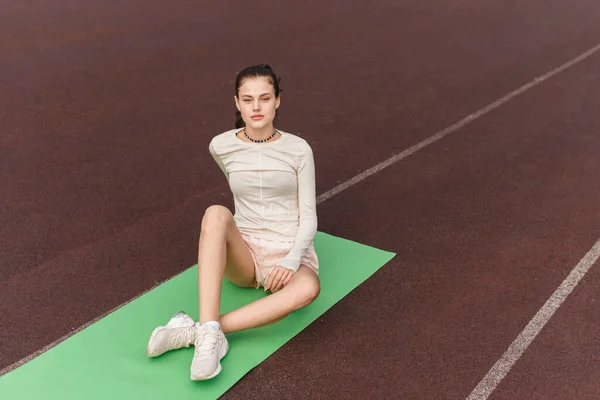 Sportief vrouwelijk mooi model gaat in voor sport buiten en kijkt naar de camera — Stockfoto